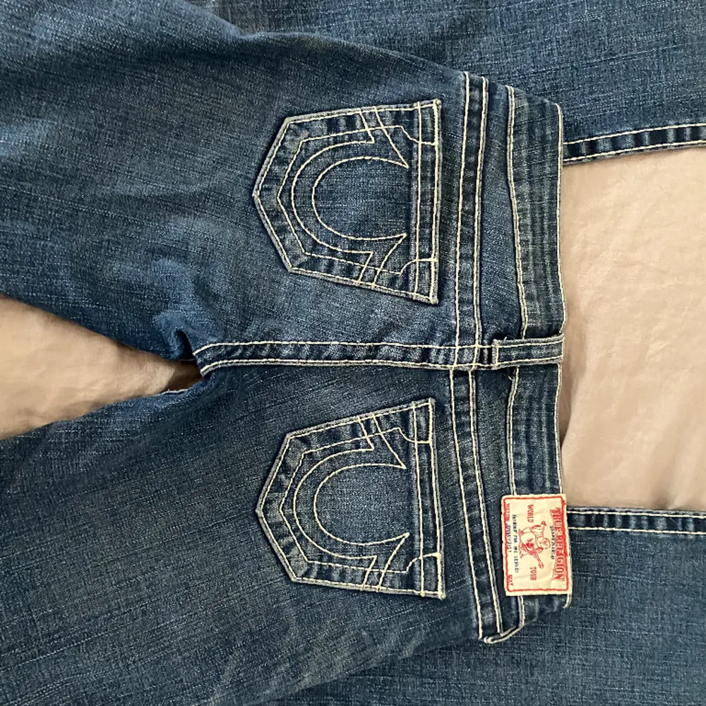Säljer dessa superfina low waist flare True Religion jeans. Köpte second hand för 800kr och säljer för 450kr(pris kan diskuteras). Skriv för fler bilder eller frågor. Storlek 26. Är i utmärkt skick och har slit vid benen💕💕. Jeans & Byxor.