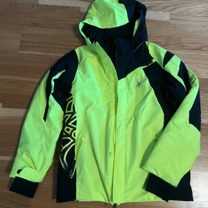 Skidjacka - Gul och svart skidjacka i nyskick. Perfekt för dig som vill synas i backen. 