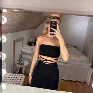 Svart kjol med snörning  - Svart längre kjol med snörning runt midjan från Na-kd. Kjolen är endast använd en gång. 