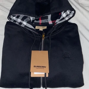 Burberry zip hoodie  - En oanvänd svart Burberry zip hoodie.  Kontakta mig vid övriga frågor och funderingar. 