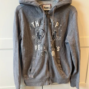 Hoodie Pepe jeans - Säljer denna grå Hoodie från Pepe jeans i storlek M. Säljer då den inte kommer till användning längre. PRIS KAN DISKUTERAS 