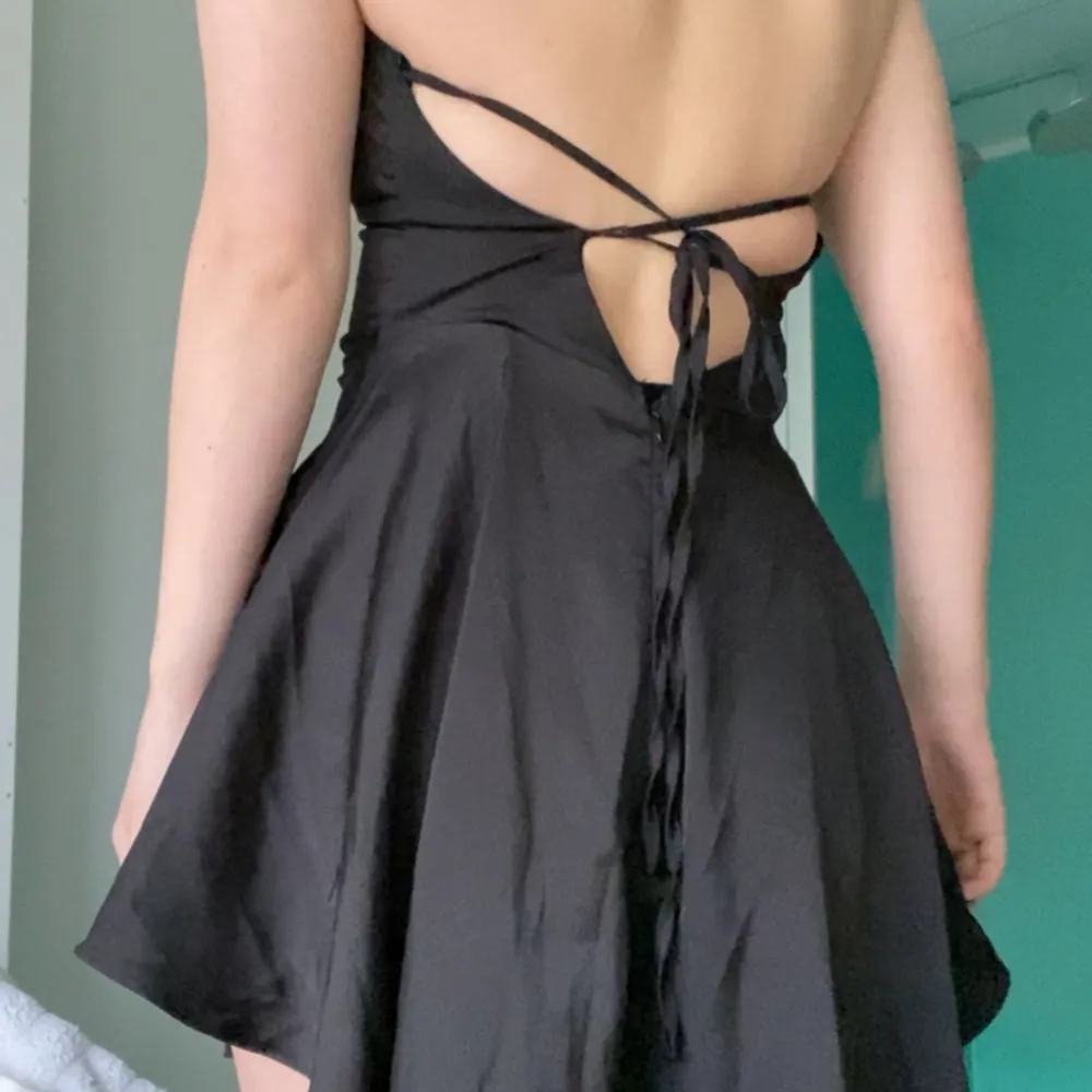 Svart klänning i satin storlek XS med knytning i ryggen. Klänningar.