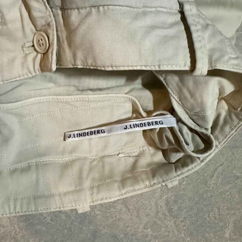 Ljusbeige cargobyxor från J. LINDEBERG. Byxorna är helt oanvända. . Farkut & Housut.
