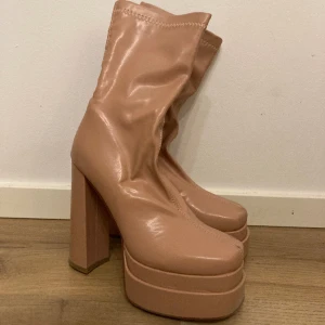 Klackar simmi - Beigea klackar från Simmi London i fake-läder. Skorna köptes för  2 år sedan och har använts ca 3 gånger men har en del märken på sula och lite smuts ovanpå som syns på bilderna. Hög klack och platå