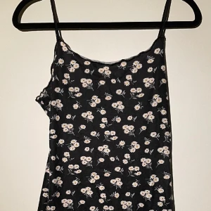 Blommig tajt klänning  - Super fin sommarklänning, sitter tajt och skit snyggt & formas efter kroppen. Lite volang upp till och nedtill - se bild. Man kan vika ner/in uppe delen och göra det till en kjol med. 