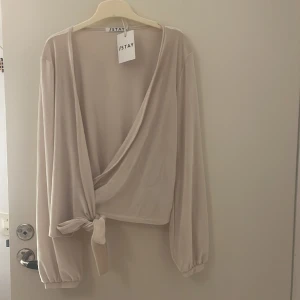 ”wrap” topp - Snygg ”wrap around” topp som tyvärr inte har använts. Är i väldigt skönt material, sammet! Nyskick med prislapp!