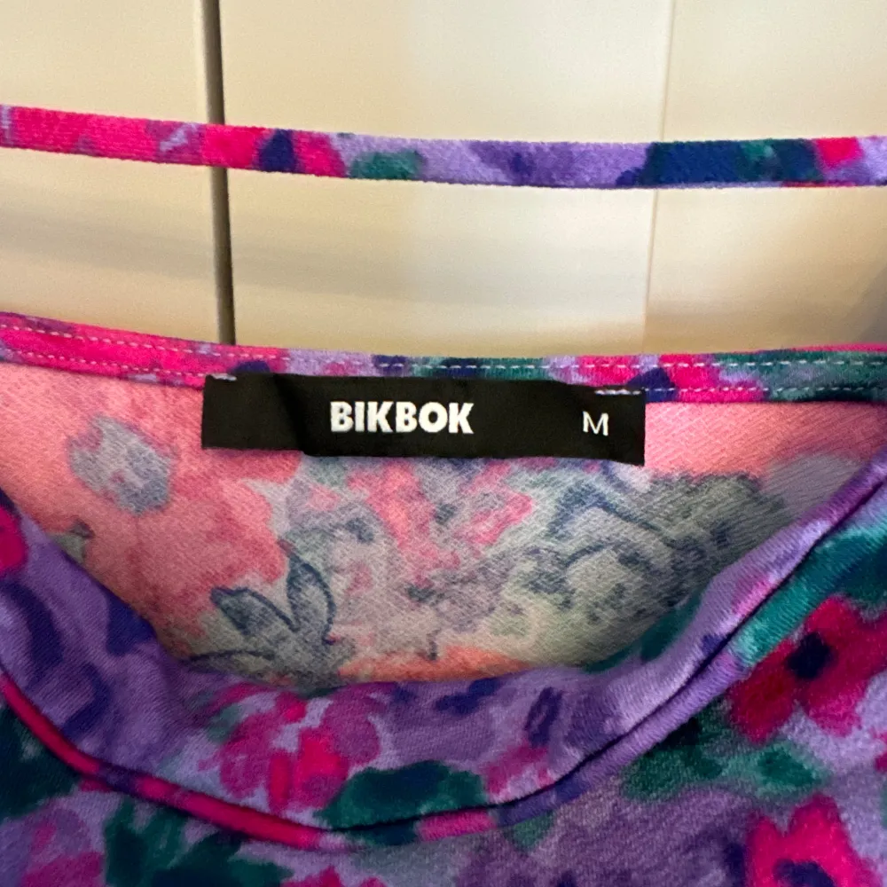 Somrigt, färgstarkt linne med blommor från BikBok. Köptes inför sommaren förra året men har aldrig kommit till användning. Storlek M, men passar även S. Inga defekter, är som ny!💕. Toppar.