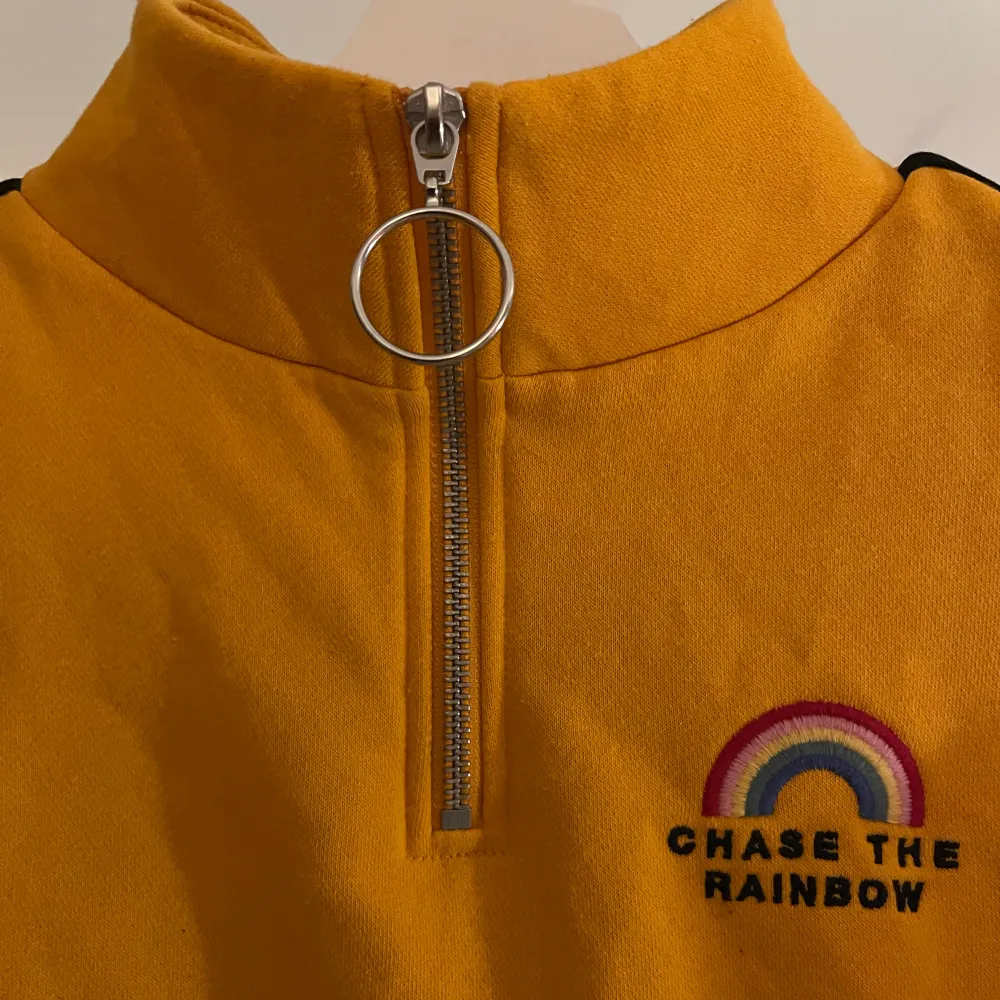 En cropped senapsgul turtleneck tröja med dragkedja upptill samt tryck av en regnbåge och en text under där det står ”chase the rainbow”!🌟 Från H&M i strl XS, knappt använd!💓. Hoodies.