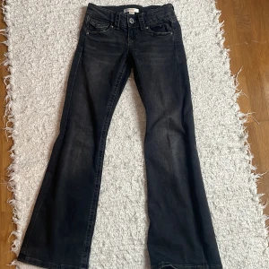 Low waist jeans med knappar där bak - Svarta low waist jeans med knappar på fickorna där bak, jätte fina och endast använda 1 gång!