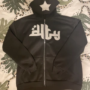 Y2k ziphoodie - Säljer en fet y2k hoodie som är trendig och matchar till mycket! Den har inge defekter, endast lite nopprig, ca 8/10 skick. Därav ett väldigt prisvärt pris! Passar unisex. Kontakta vid minsta intresse och vid frågor!