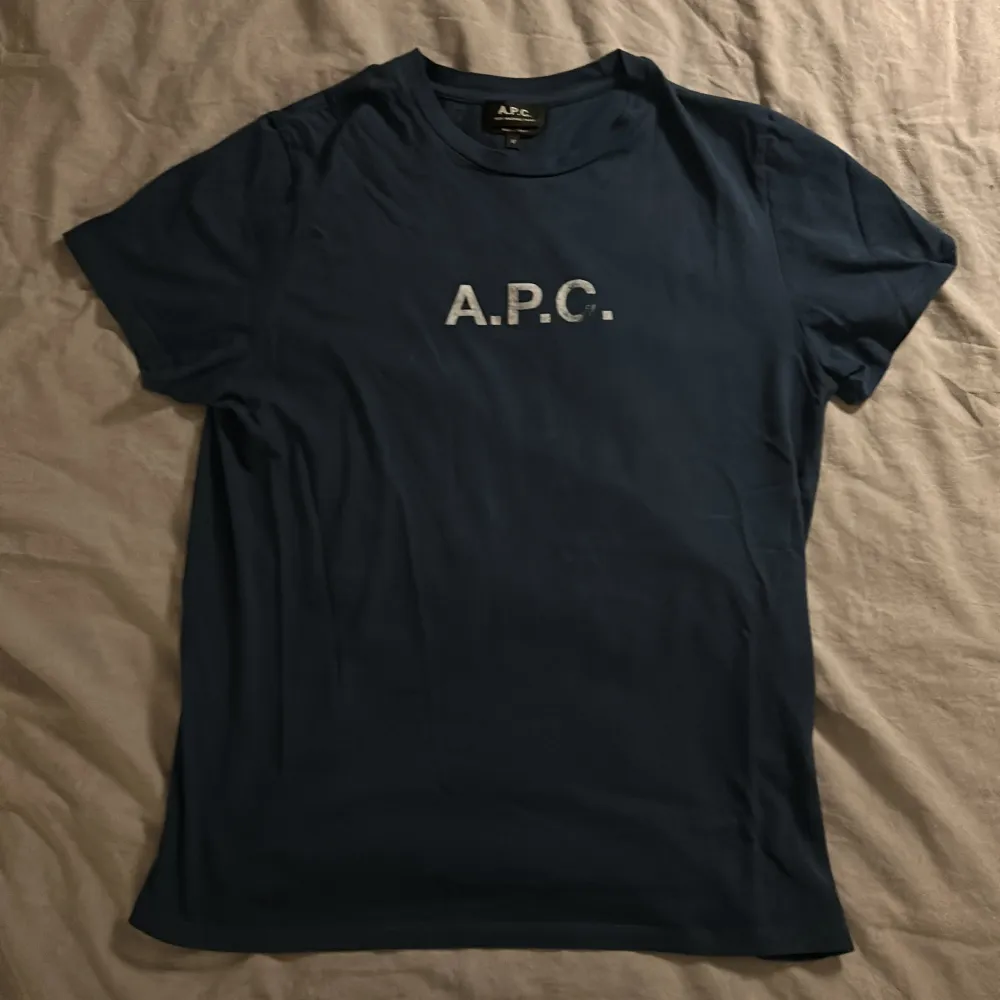 Mörkblå APC Tshirt i extremt bra skick! Inga defekter överhuvudtaget (textens slitning är del av designen). Nypris ligger på runt tusenlappen. Säljes då den inte passar mig.. T-shirts.
