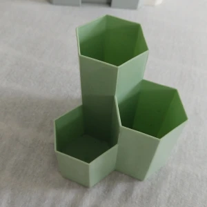 Grön hexagonformad förvaringsbehållare - En grön förvaringsbehållare med tre hexagonformade fack i olika höjder. Perfekt för att organisera småsaker på skrivbordet eller i hemmet.