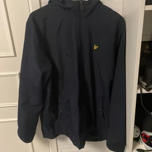 Regnjacka lyle & scott  - En lyle & scott regn/vindjacka som jag köpte på Zalando förr förra året säljer den då jag har köpt en ny inga fel på den. Har klippt bort en flärp på luvan som hängde ner det är därför det är lite trådar på luvan. Skick 7/10