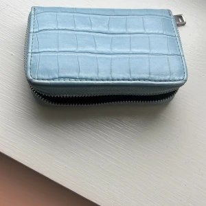  Blå plånbok -  En blå plånbok som har varit väldigt mycket använd men dags att säga farväl för jag gillar inte den längre