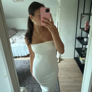 Vit tub klänning med slits - Jag säljer min jätte fina tub klänning med slits där bak. Den är använd fåtal gånger och är i väldigt bra skick, skriv vid frågor💕💕💕