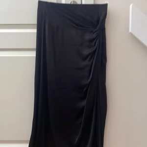 Lång kjol med slits och kort kjol under  - Långkjol med en slits, liten kort kjol under. Dragkedja baktill. Aldrig använt! Helt ny