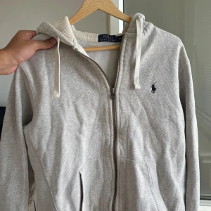 Ralph Lauren hoodie - Grå - En grå hoodie från Ralph Lauren i mycket bra skick. Säljer pga för liten, passar någon som är 170-180cm. Nypris 2 195kr. 