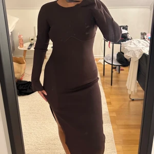 Brun lång klänning med slits - Säljer denna snygga bruna klänningen ifrån Ida Carlsson X Nakd kollition som har utgått! Aldrig använt!!