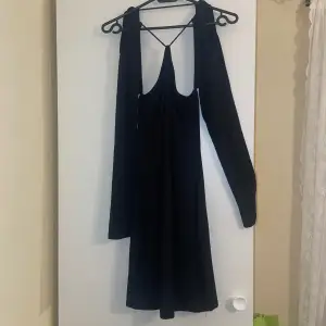 En super fin svart klänning som är perfekt för fester. Öppen rygg. Använd en gång. PRIS KAN DISKUTERAS!
