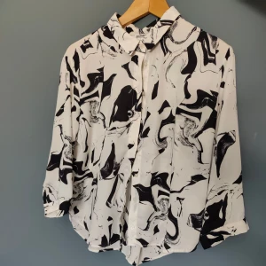 Kort skjorta/blus - En skjorta i skirt tyg och lös kort modell. Storl. L från Monki.  Knappt använd.