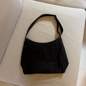 En större shoulderbag från Weekday, får plats med mycket i den. Har en mindre ficka inuti och ett justerbart band. Väl använd så har lite slitage (skriv för bilder)