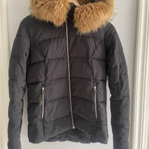 Dunjacka från Race marine - Varm och mysig dunjacka med fuskpäls på luvan (kan tas av).  Finns några diskreta fläckar framtill, syns inte så mkt men därav lågt pris. 