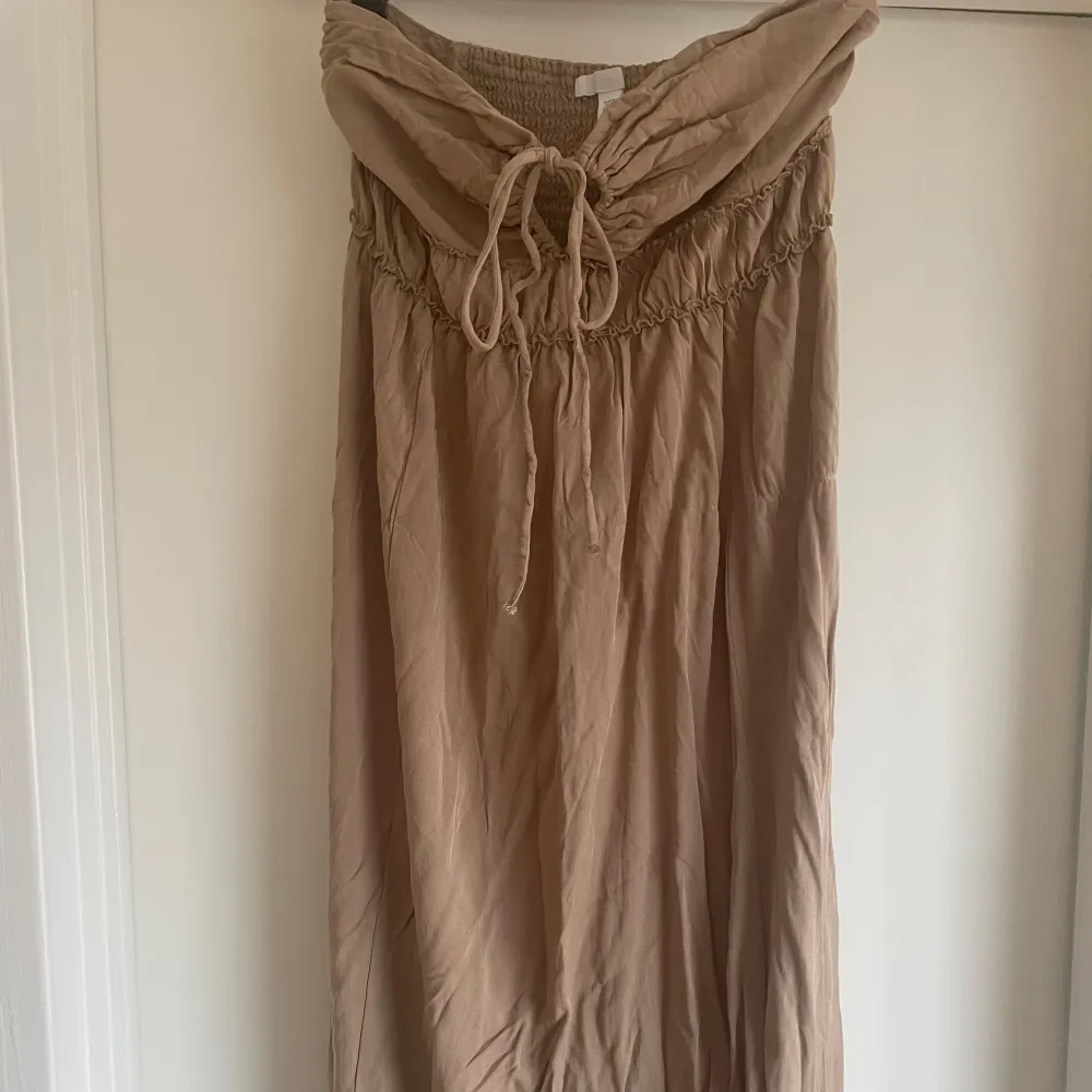En jättefin beige/brun bandeau klänning från hm, går även att knyta runt halsen🤎 aldrig använd. Klänningar.