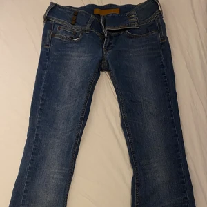 Gina tricot low waisted byxor strl 28(xs) - Snygga utsvängda lowrise jeans som nästan inte använda! Dom är i storlek 28 och är i medel längd. De är mörkblå med ett inbyggt skärp💕 säljer för att ge liv till byxor som aldrig knappt används🥲 
