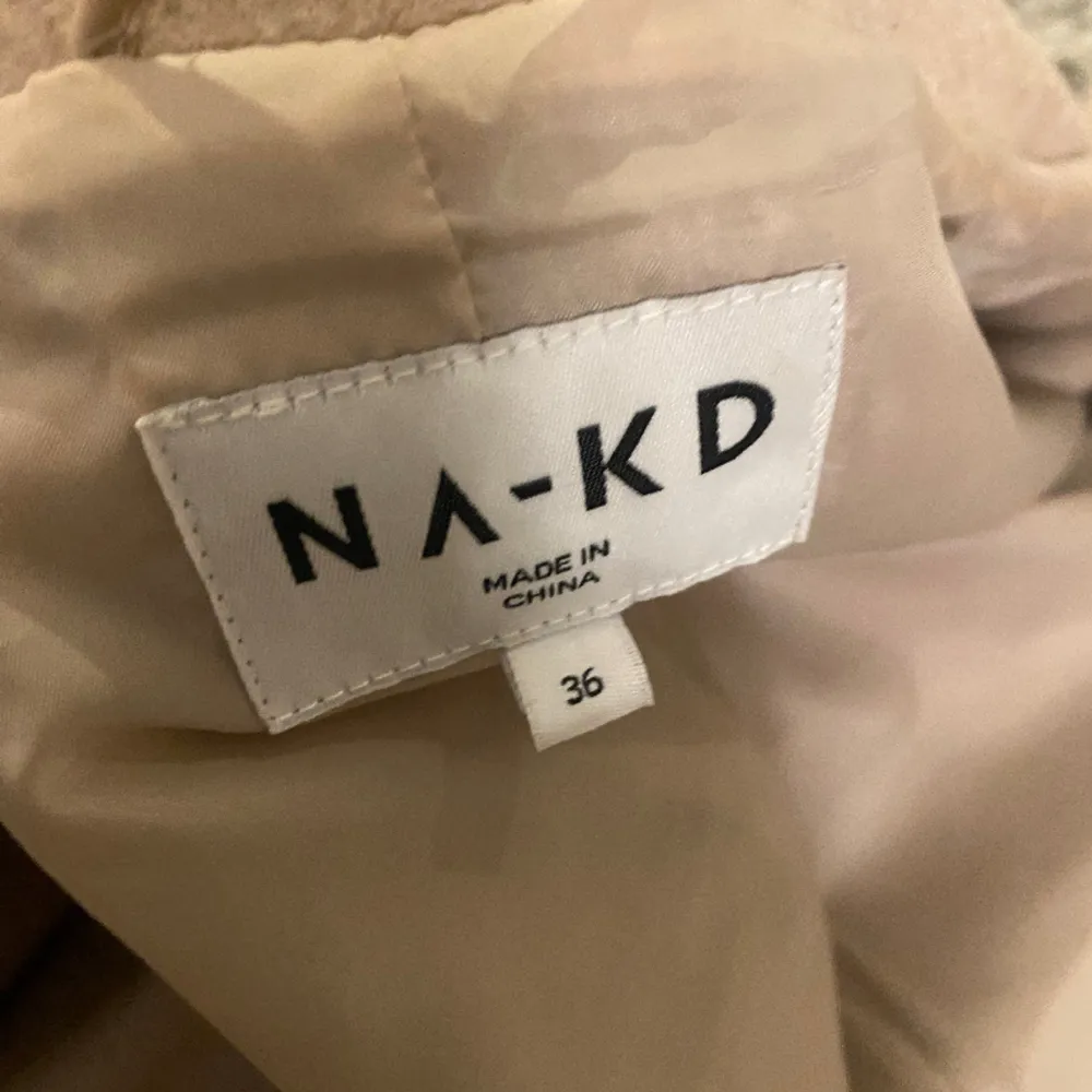 Beige kort kappa från NAKD i storlek 36, sitter oversized 🥰. Jackor.