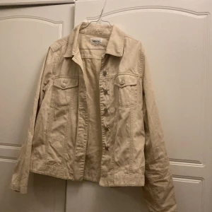 Beige jeansjacka, storlek 38/40 - En tunn jeansjacka/skjortkrages i storleken 38/40.
