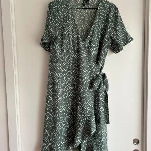 Wrap klänning Vero Moda, strl L - Grön wrap klänning med vita prickar.  Från Vero Moda storlek L Använd fåtal gånger, som nyskick