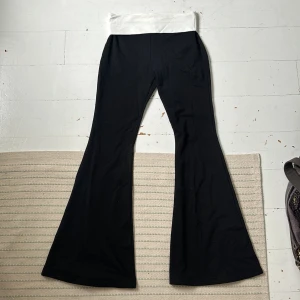 Edikted lowrise fold flare leggings + tube top - Sett från Edikted, Aldrig använt, lapparna kvar. Både tub toppen och utsvängda lågmidjade matchande byxor till, köpta för 905kr för byxor och 499kr för tröjan (just nu på rea 275kr byxor och 249kr tröjan) Säljer båda för 300kr