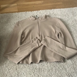 Träningströja - En beige tröja som man både kan ha under träning men även till vardags.