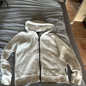Sail Racing - Säljer denna Sail Racing zip hoodien, okej skick, 6,5/10. Riktigt skön o snygg med vit som passar till allt verkligen!
