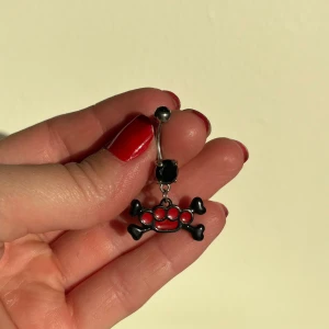 Navelpiercing knogjärn  - Svart knogjärn med röda diamanter till navelpiercing. NY! 