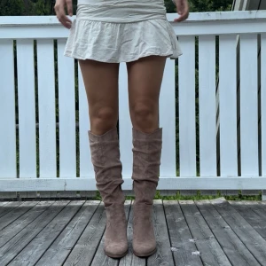Knähöga boots - Säljer ett par ursnygga beiga boots i storlek 38. Skorna har en lägre klack och slutar strax under knäna.  Dem har endast används 1 gång, så är i ett nyskick💕