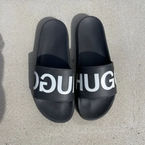 Hugo badtofflor  - Snygga svarta badtofflor av Hugo. Strl 43, dem är använda men i fint skick.