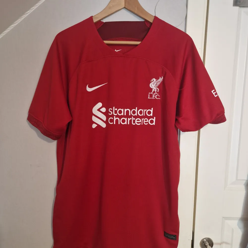 Liverpool tröja säsong 22/23 Mohammed Salah #11. Inte använd alls. Pris sänks vid snabb affär. T-shirts.