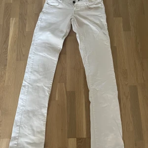 Raka vita lågmidjade jeans - Långa jeans i okej skick. Inga bakfickor. Lågmidjade och fina knappdetlajer. 