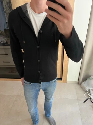 Svart stickad cardigan hoodie Massimo Dutti - Riktigt snygg stickad hoodie från Massimo Dutti! Har en identisk och det är en personlig favorit.      ——————————————————————————                                                          📐| Storlek: M                                                          👖| Märke: Massimo Dutti                                      🔎 | Skick: Väldigt bra                                              ✍🏻 | Skriv om du har några frågor