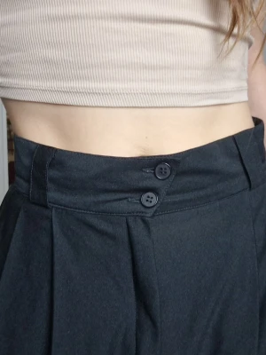 Black wide pants - Black wide pants that also looks like a skirt. All comfort, no worries! Wide waistband, fastens with buttons and zipper. Super stylish silhouette with the shape of the waist and the draping of the legs! They have been sewn in once at the waist, so it says size 38 on the label, but I would say it is size 36. Length: 87 cm. 
