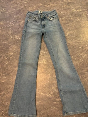 Ljusblå bootcut jeans - Säljer ett par klassiska jeans i ljusblå tvätt med bootcut passform. Perfekt för dig som gillar retrovibbar och snygg siluett.