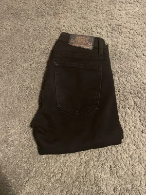 Svarta skinny jeans från Core Man W28/L32 - Svarta jeans från Core Man med skinny fit och regular midja. Snygg, smal siluett med klassisk femficksdesign och läderpatch bak. Materialet är stretchigt jeans för skön passform. Perfekt för dig som gillar en stilren och modern look.