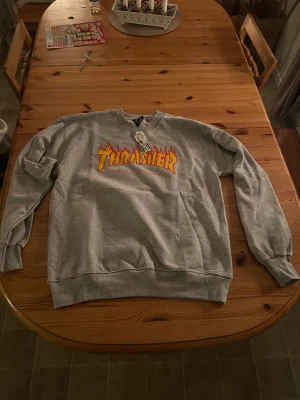 Grå Thrasher sweatshirt. (GE PRISFÖRSLAG) - säljer oanvänd grå trasher tröja i storlek M, lite stor i storleken