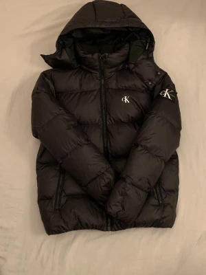Svart dunjacka från Calvin Klein - Svart dunjacka från Calvin Klein som är väldigt bra skick och passar en som bryr sig om sina kläder.