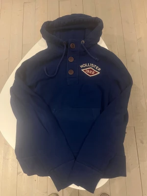Hollister California hoodie mörkblå  - Hollister California hoodie mörkblå färg med knappar väldigt sällsynt och säljs inte längre.storlek M/S och passar 171-180 cm lång Väldigt bra skick 8,5/10 pris 488 kr!! Kolla gärna mina andra annonser för mer och rabatt vid köp av fler 😃