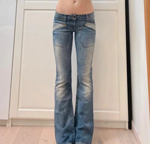 bootcut jeans - Säljer ett par snygga only jeans med bootcut och låg midja. De är ljusblå med slitningar och har coola fickdetaljer fram och bak, samt röda sömmar på bakfickorna.                                      Gren: 17,5 cm                                                     Midjemått: 38 cm                                                inneben: 81cm                                                              lår: 21 cm  Inte mina bilder🩷