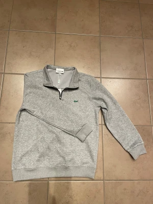 Lacoste quarter zip  - Riktigt fet grå tröja från Lacoste lappen sitter kvar då den är helt ny men tyvärr var den lite för liten för mig. Storlek M men sitter nog mer som S skulle jag säga. Bara att höra av sig vid frågor. Mvh Algot