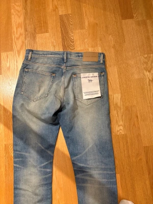 Nya  jeans från Tiger of Sweden - Säljer ett par snygga blå jeans från Tiger of Sweden med klassisk femficksdesign och ljusa slitningar. Storlek 31/32. Skriv vid funderingar. Helt nya använda en gång. Till och med lappen är kvar(första bild) 