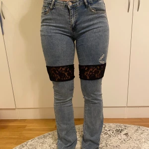 Ljusblåa bootcut jeans med svart spets - Vår första design blir verklighet!! Förlängningen sker nu mitt på låret🤯vilket vi tycker är ashäftigt!! Jeansmaterialet är väldigt stretchigt men spetsen är tyvärr inte lika stretchig vilket gör att den lårvidd som står kommer jeansen passa bäst på💙Strl M är en uppskattning så vi rekommenderar att mäta sig själv och kika på måtten i sista bilden!!😊Hör av dig vid frågor!!